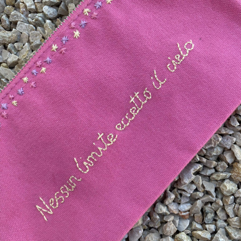 pochette con frasi di viaggio rosa